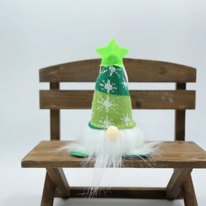 Detail of green knit Christmas gnome with snowflake pattern and glowing star on its hat