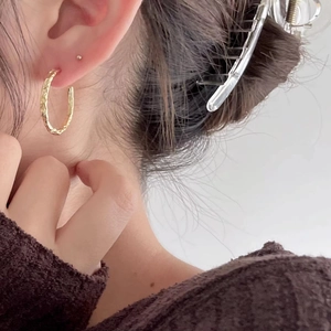 Minimalist hammered gold C-shaped hoop earrings on model with Nordic style design