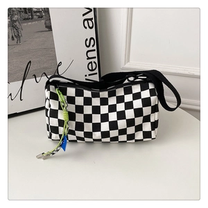 Close-up of black and white checkerboard Boston bag with colorful rope zipper detail