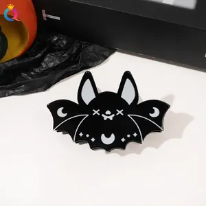 Close-up of black bat hair claw clip with moon and star patterns for Halloween decor