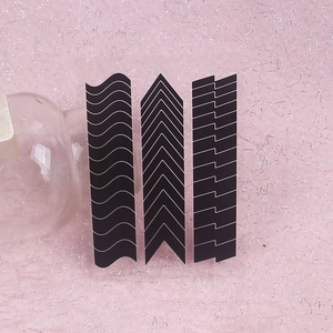 Three sheets of black nail art stickers with wave, V-shape and line patterns on pink background