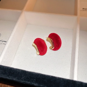 Détail macro de boucles d'oreilles rétro en velours rouge avec bordure dorée