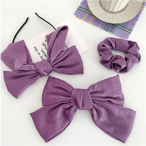 Purple satin hair accessories set featuring oversized bow headband, clip, and scrunchie