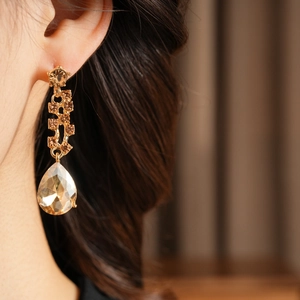 Macro shot of champagne gold drop earrings with pear-cut gems and cubic zirconia