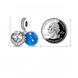 Macro detail of S925 silver star and moon charm next to a coin for size comparison