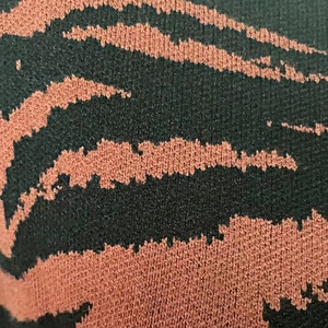 Gros plan détaillé du motif jacquard tigre léopard sur une robe en maille dense