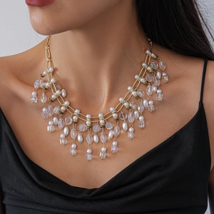 Detailed view of layered gold tassel necklace with pearls and faceted clear beads