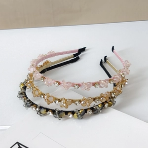 Macro detail of three handmade crystal beaded headbands in pink, gold and black
