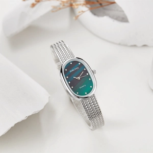Detailed macro view of an oval emerald green quartz watch dial with mesh steel band