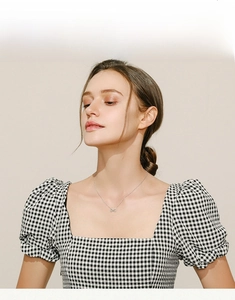 Model wearing a minimalist S925 silver infinity symbol pendant necklace on a thin chain
