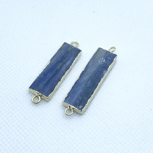 Macro detail of rectangle blue kyanite pendants with gold plated edges and double loops