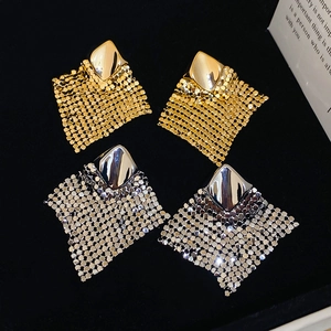 Detailed macro view of geometric metal mesh earrings in gold and silver finishes