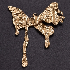 Macro shot of 304 stainless steel golden butterfly pendant with molten texture on black