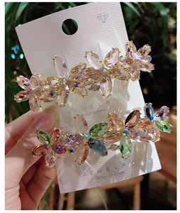 Detail of floral hair clips with sparkling crystals in champagne and multicolor tones