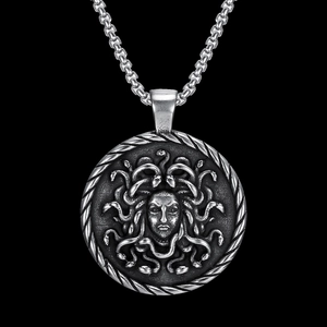 Macro detail of silver Medusa relief pendant with polished stainless steel box chain