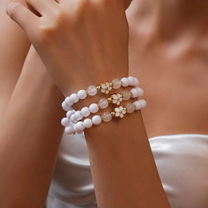 Close-up of a 3-piece acrylic beaded bracelet set with gold-edged flower charms