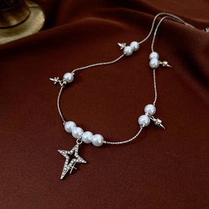Détail du collier de perles Saturne avec étoiles en strass sur velours foncé