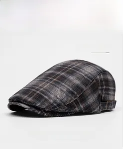 Close-up of grey grid newsboy cap featuring a retro plaid pattern and metal side buckle