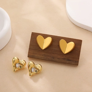 Detailed view of 18K gold heart studs with textured finish and cubic zirconia inlay