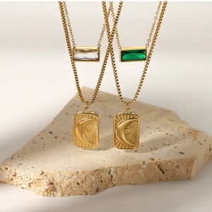 Detail of double-layer gold necklaces with sun moon charms and green zircon rectangle pendants