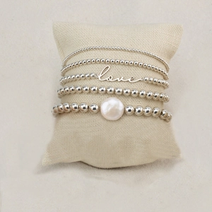 Five-piece silver bead bracelet set with LOVE charm and baroque pearl on a cushion