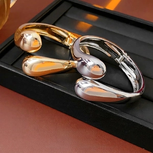 Minimalist polished metal open cuff bracelet with teardrop design in gold and silver