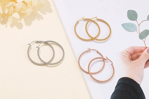 Three pairs of beaded hoop earrings in silver, gold and rose gold finishes