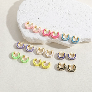 Set of 10 colorful enamel C-shape hoop earrings with gold trim on stone pedestal