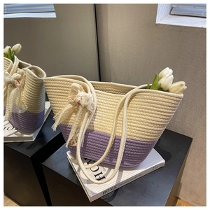Detail of hand-woven cotton rope tote bag with beige and purple splice and floral ribbon
