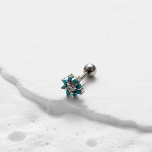 Macro view of flower stud earring with turquoise beads and clear center stone on stone