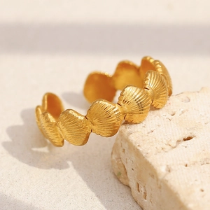 Vue macro détaillée d'une bague coquillage plaquée or 18 carats sur fond de pierre