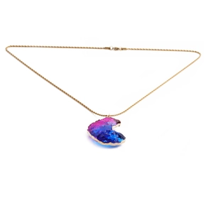 Detailed close-up of a golden twist chain necklace with a purple star-shaped gemstone pendant