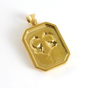 Detail of 18K gold stainless steel pendant featuring a 3D embossed bow design