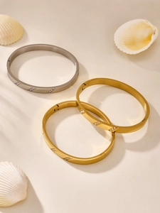 Detailed close-up of brushed stainless steel bangles with micro-inlaid cubic zirconia