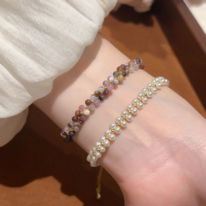 Detailed close-up of double-layered beaded bracelet with white pearls and natural stones