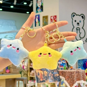 Detailed macro view of three colorful plush star keychains with embroidered faces