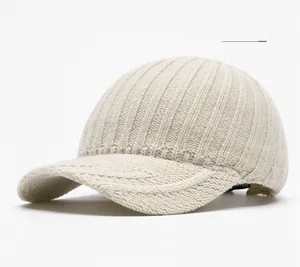 Close-up of the beige ribbed knit texture and curved brim of the winter baseball hat