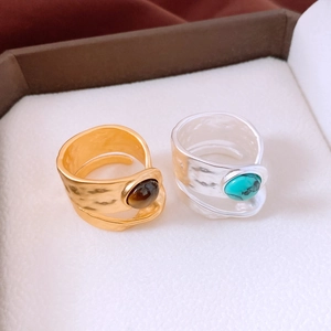 Macro shot of gold and silver hammered rings with turquoise and tiger eye stones