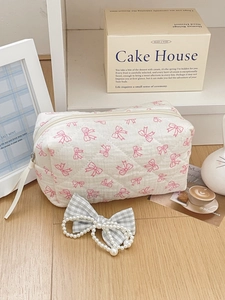 Detail of pink bow quilted cotton cosmetic bag with pearl bow hair clip in cozy setting