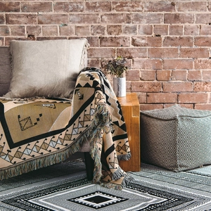 Detailed knit texture of bohemian throw blanket with tassels on a sofa arm