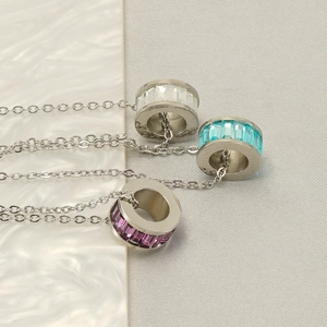 Three crystal-encrusted stainless steel cylinder pendant necklaces in white, blue and purple