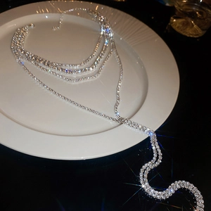 Macro detail of multilayer silver tassel necklace with sparkling rhinestone fringe