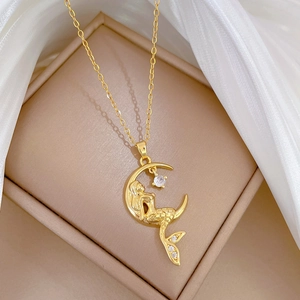 Golden mermaid on moon necklace with zircon stones on a soft white background
