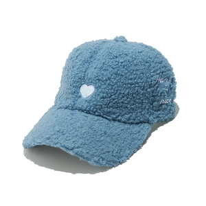 Detail of blue faux shearling baseball cap featuring white heart and side embroidery
