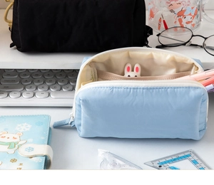 Macro detail of puffy light blue pencil case showing internal mesh storage and large capacity