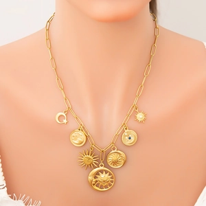 Gold paperclip chain necklace featuring sun moon and star pendants on a female model