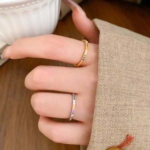 Detail of colorful zircon rainbow rings in gold and silver finish worn on fingers