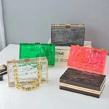 Group display of acrylic evening clutch bags in multiple colors with gold metal chains