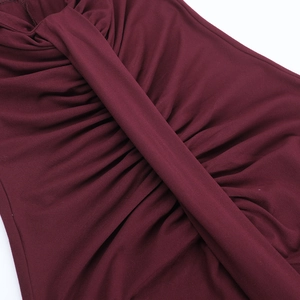 Detail of burgundy ruched bodycon dress showing texture and draped fabric folds