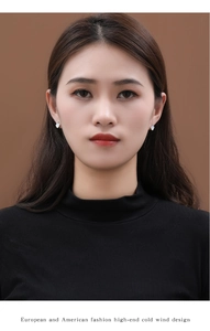 Detail of ginkgo leaf stud earring with white shell inlay worn by model on ear